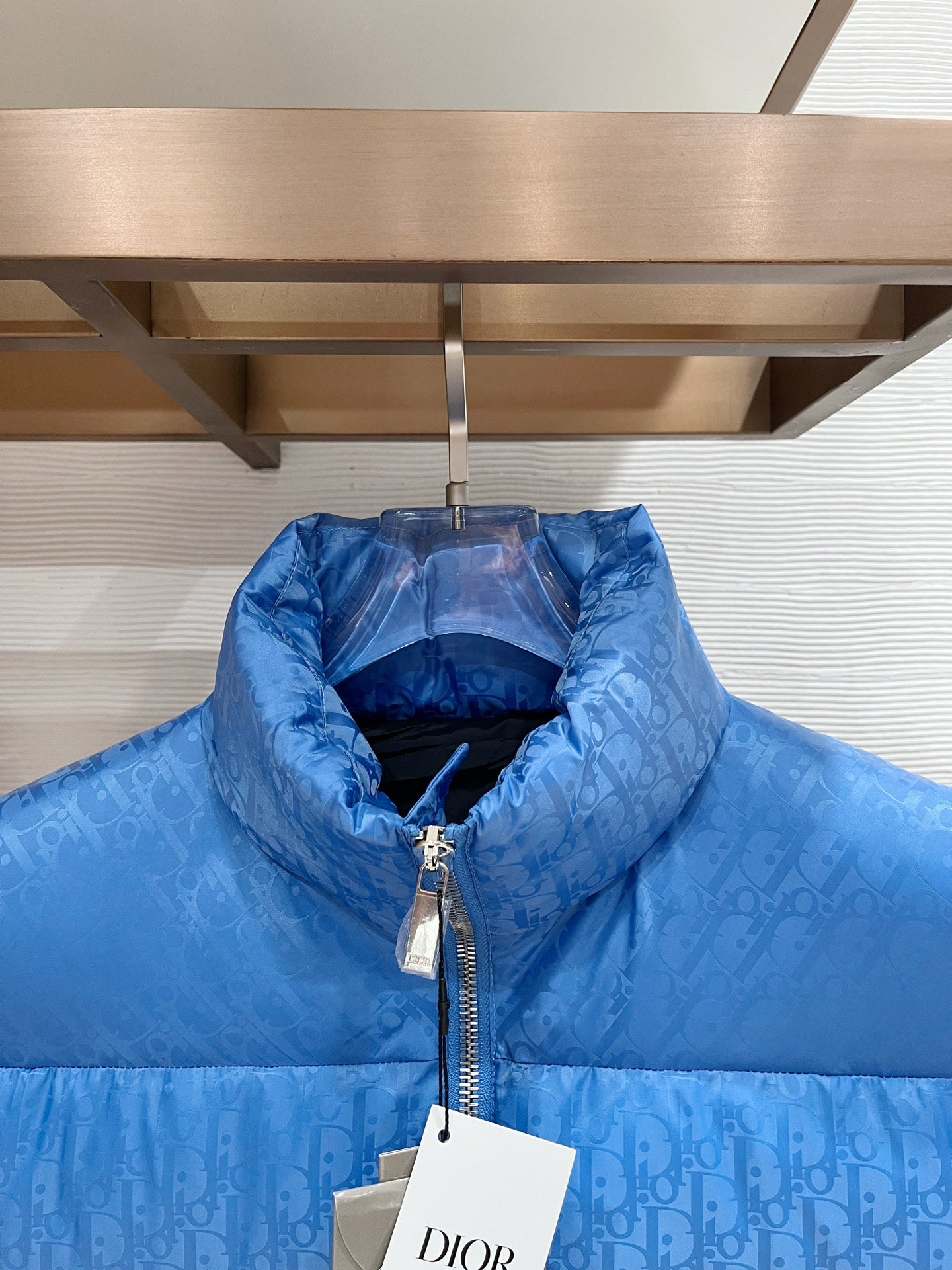 Blue quilted puffer vest with raised stand collar and front zipper close-up