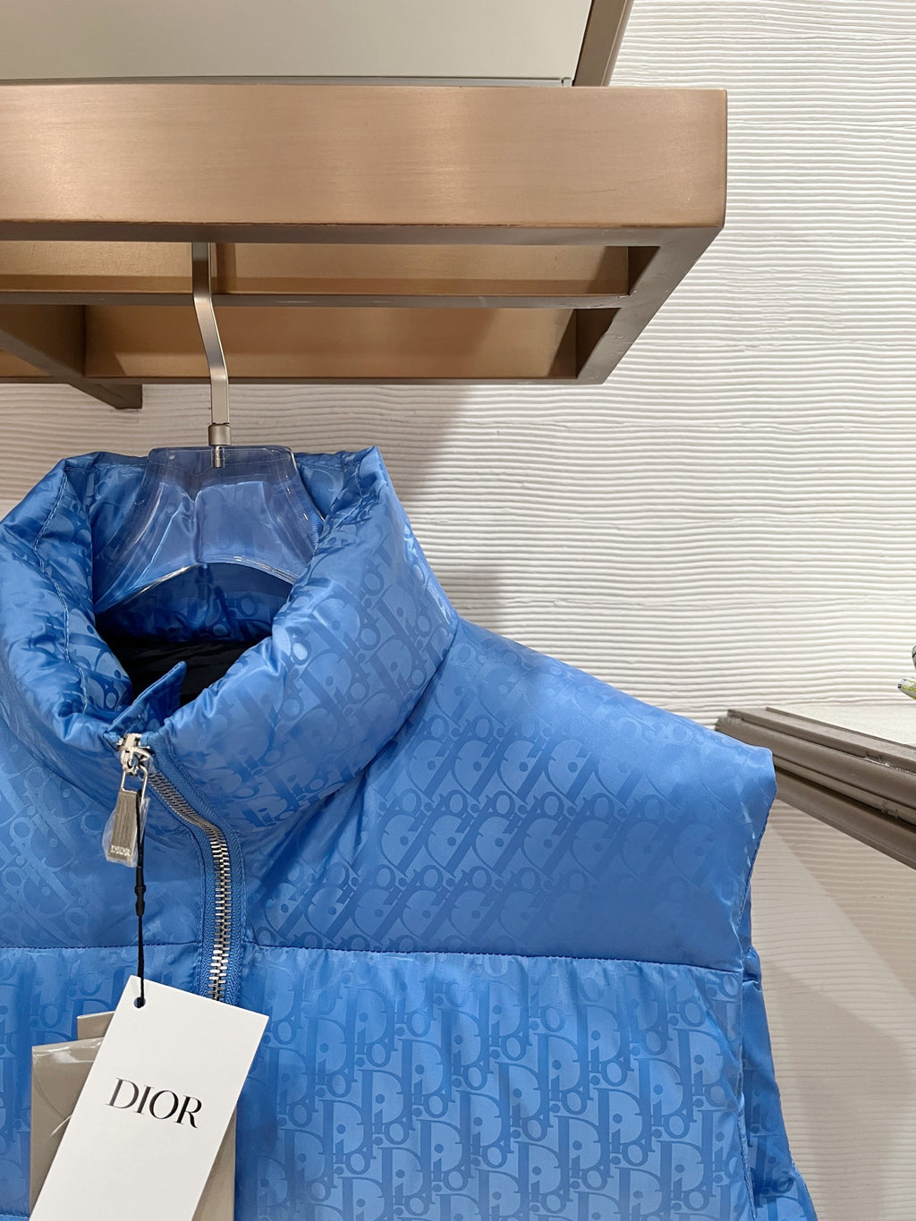 Blue quilted puffer vest with stand collar, front zipper, and hang tag