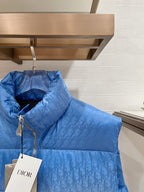 Blue quilted puffer vest with stand collar, front zipper, and hang tag