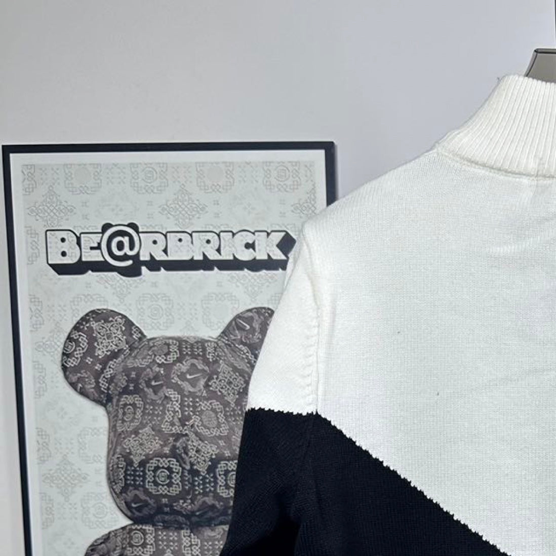 White and navy knit zip-up sweater with ribbed collar and back logo placement