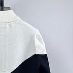 White knit zip-up sweater with ribbed turtleneck and diagonal navy panel at side