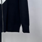 Navy knit zip-up sweater sleeve and side seam with ribbed cuff