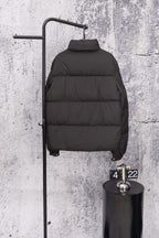 Long black puffer jacket with high neck and quilted baffles