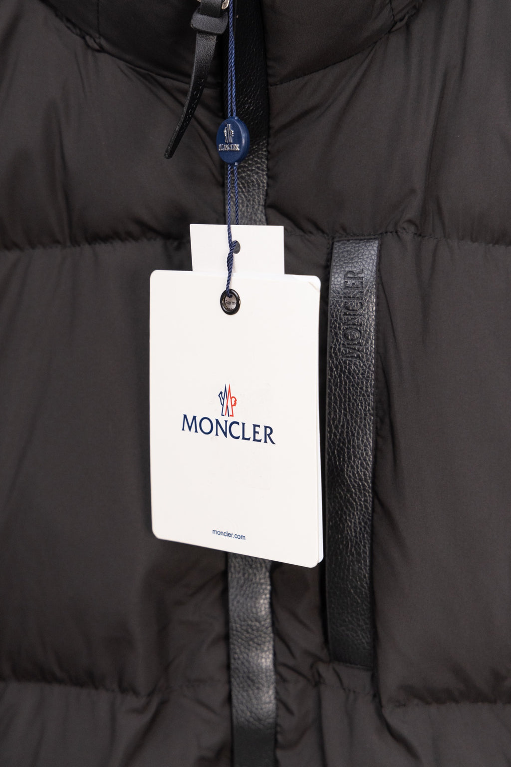 Long black puffer jacket with Moncler logo hanging tag