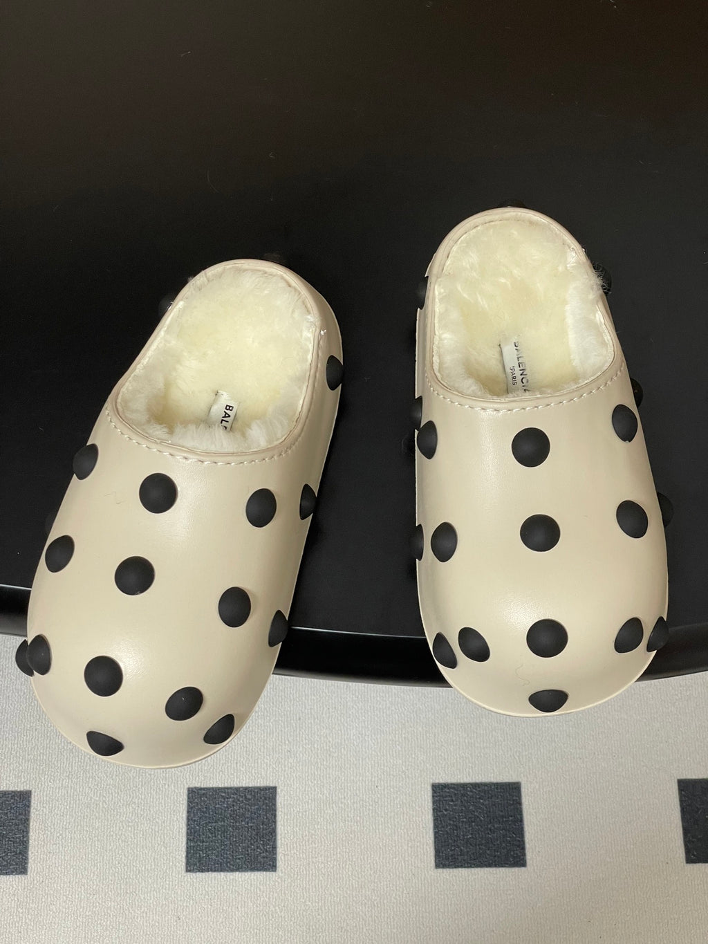 Pair of cream polka-dot clogs with shearling lining, side view