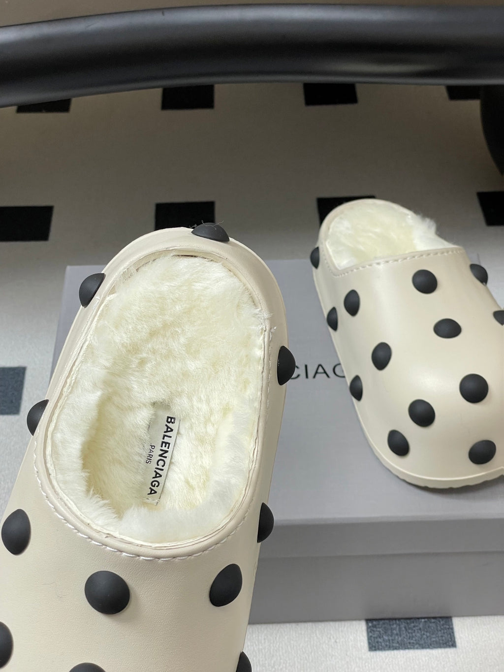 Cream polka-dot clogs with interior shearling and stitched upper, heel view
