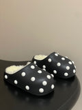 Black polka-dot slide sandals with white dots and fuzzy shearling lining.