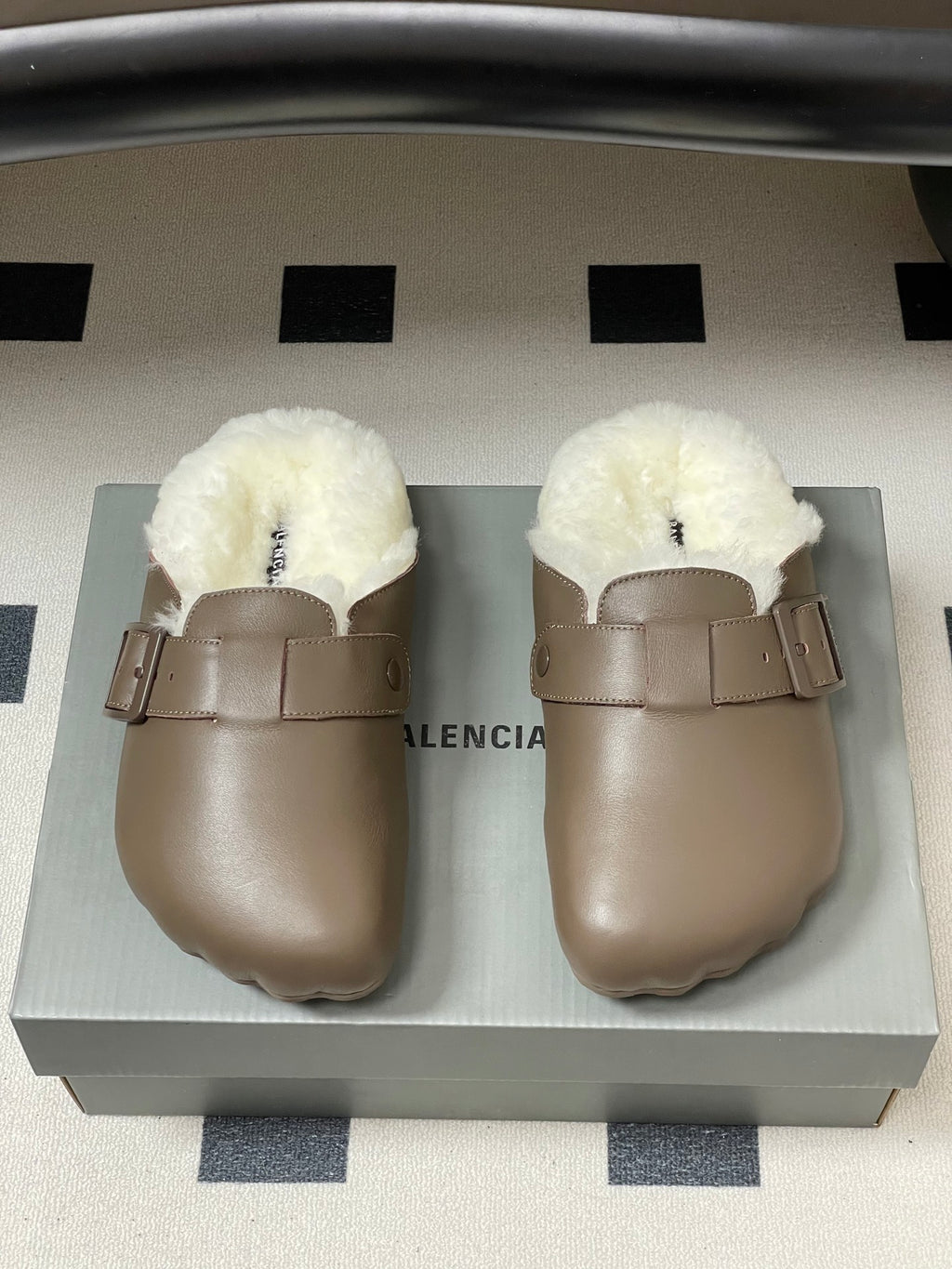Taupe shearling-lined slide sandals on display box, front view.