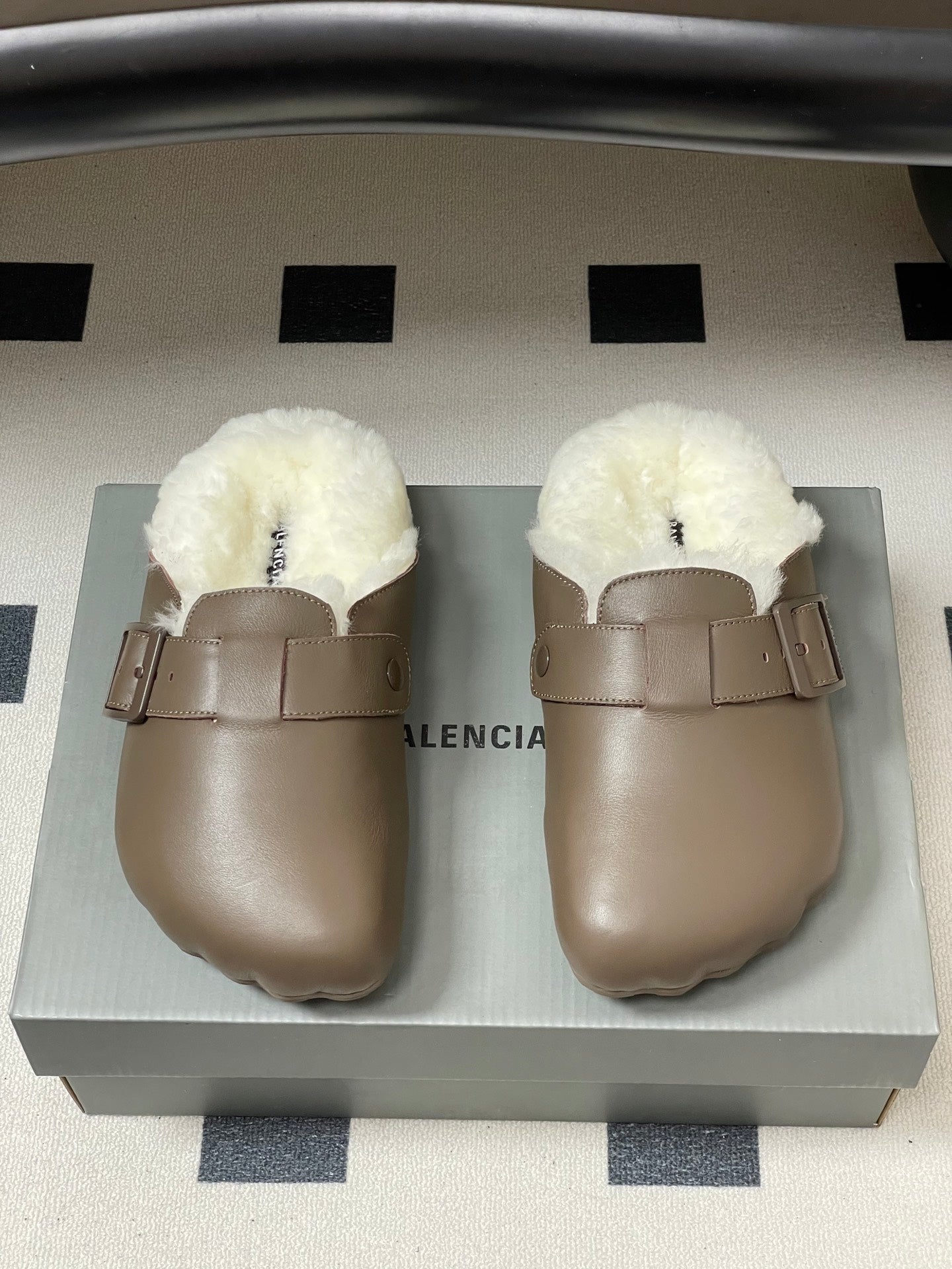 Taupe shearling-lined slide sandals on display box, front view.