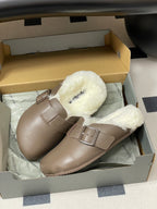Pair of taupe shearling buckle sandals in a retail box