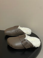 Taupe shearling-lined sandals with single buckle strap, side view.