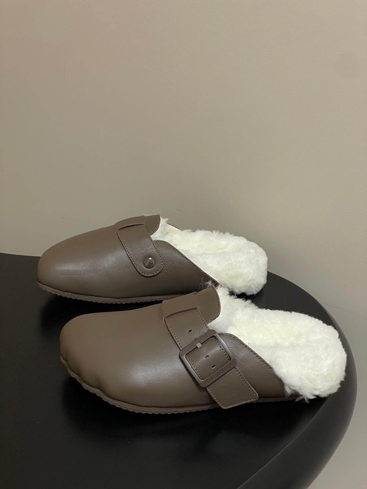 Taupe shearling slide sandals with top strap and round buckle detail