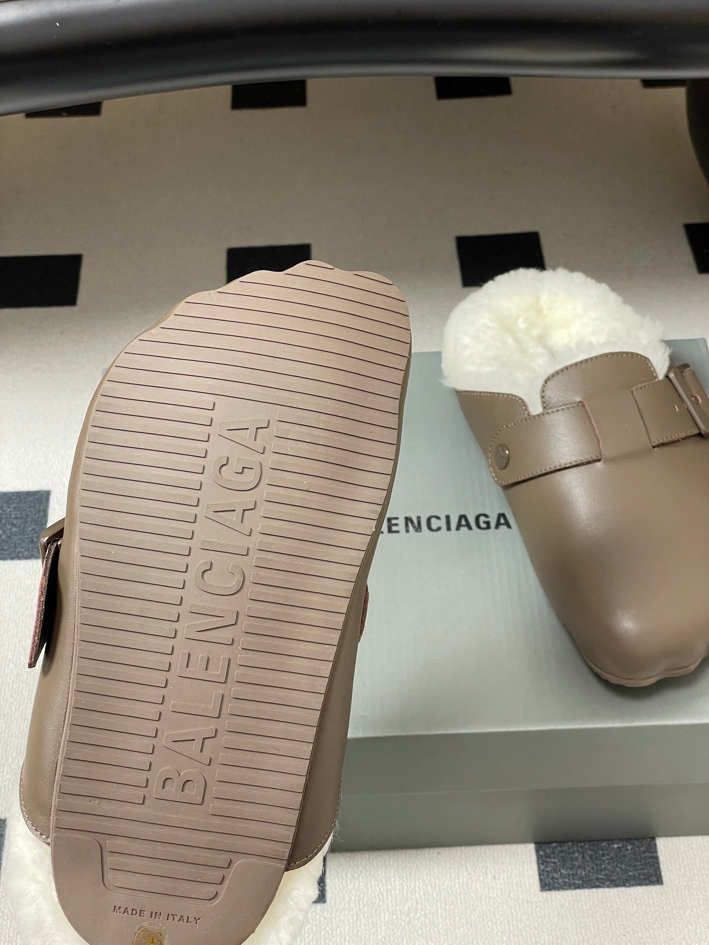 Taupe sandal outsole and matching shearling slide sandal on box