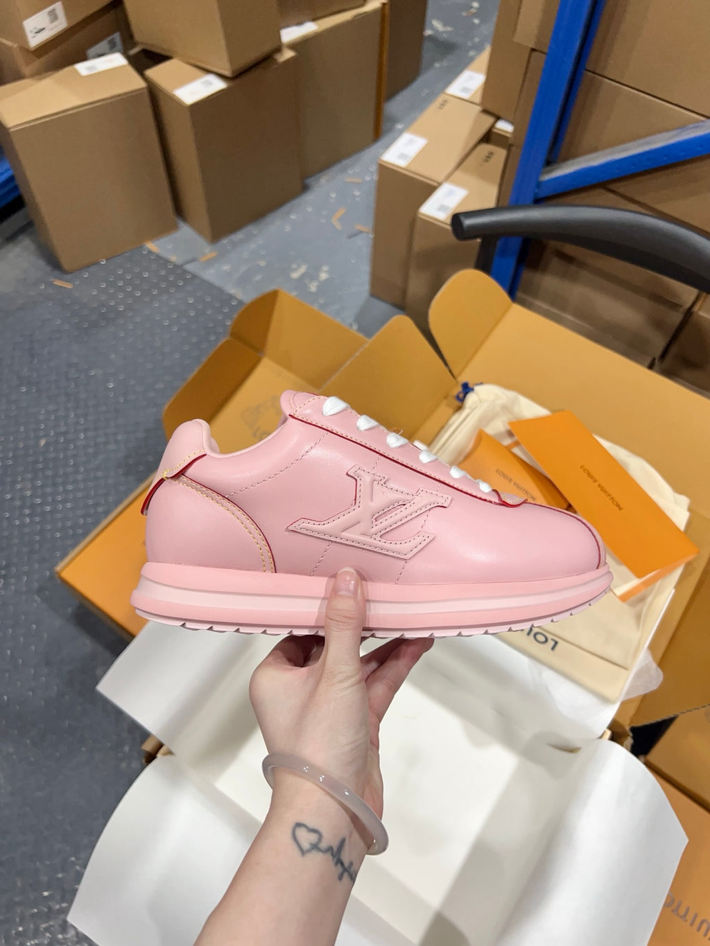 Pink leather sneakers with lace-up top, side logo patch, and white sole