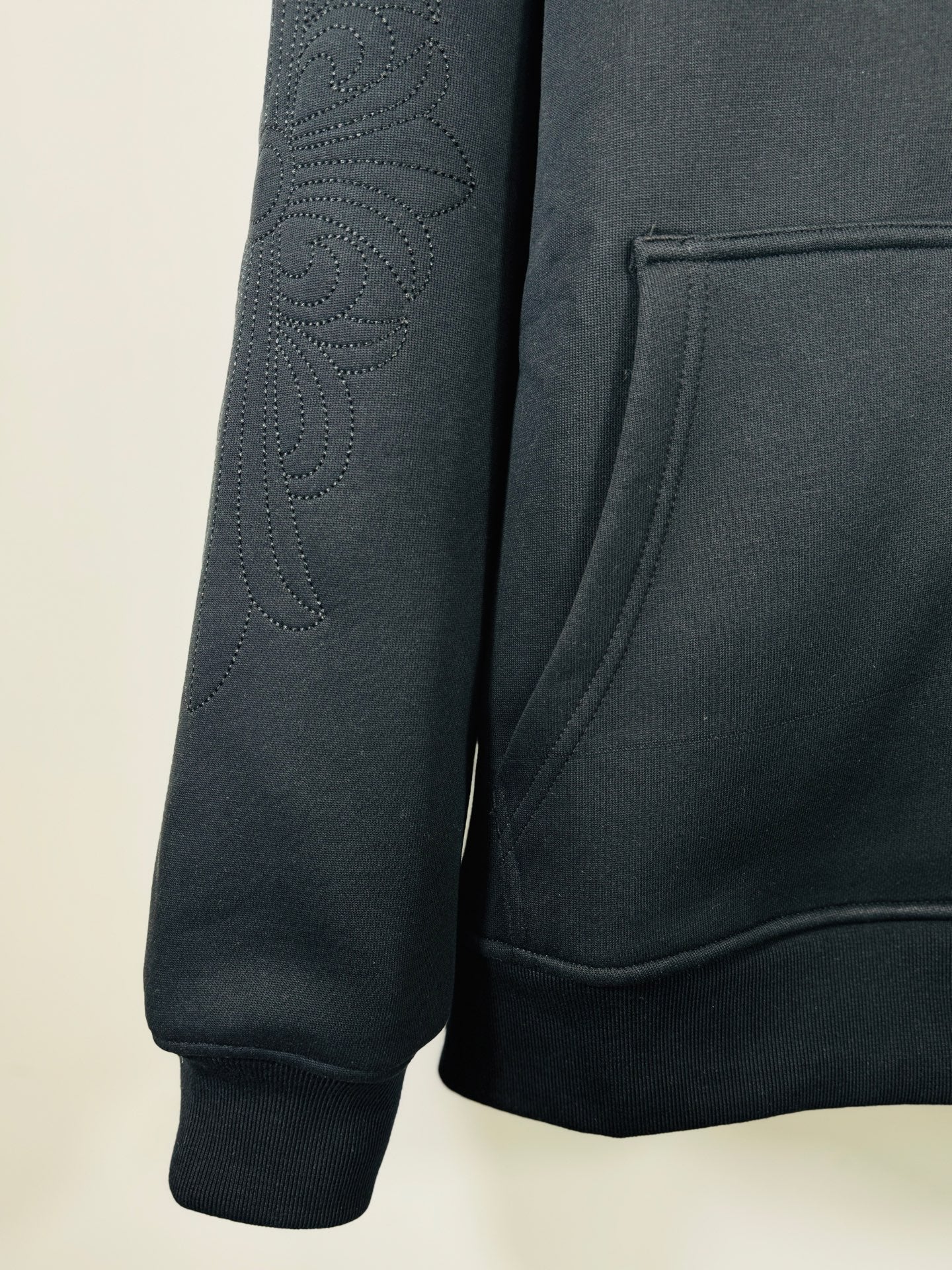 Chrome long dark hoodie sleeve, textured cross embroidery on arm