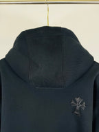 Black long-sleeve hoodie with front pocket and small cross chest patch