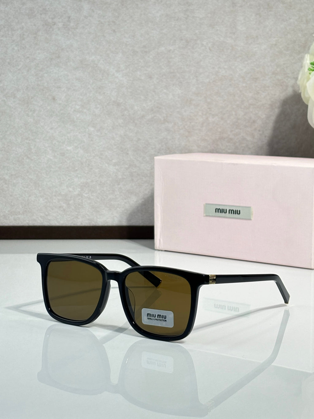 MiuMiu glasses with black frames and dark olive-brown lenses