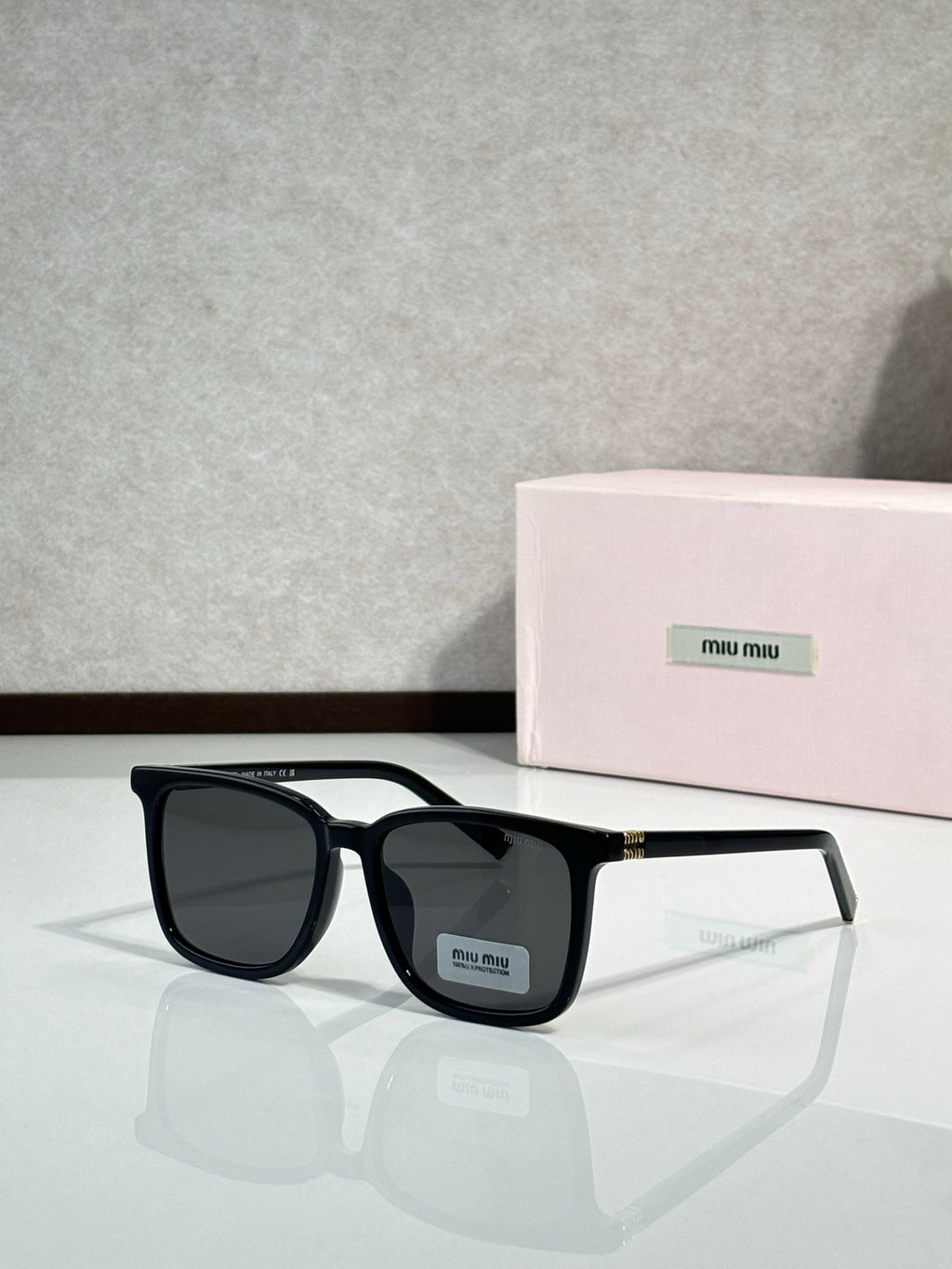 MiuMiu glasses with black rectangular frames and dark gray lenses