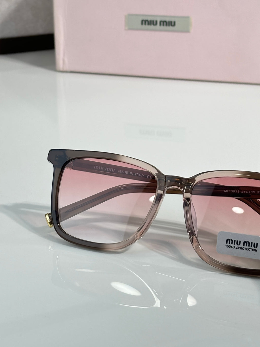 MiuMiu glasses close-up with brown frames and pink tinted lenses