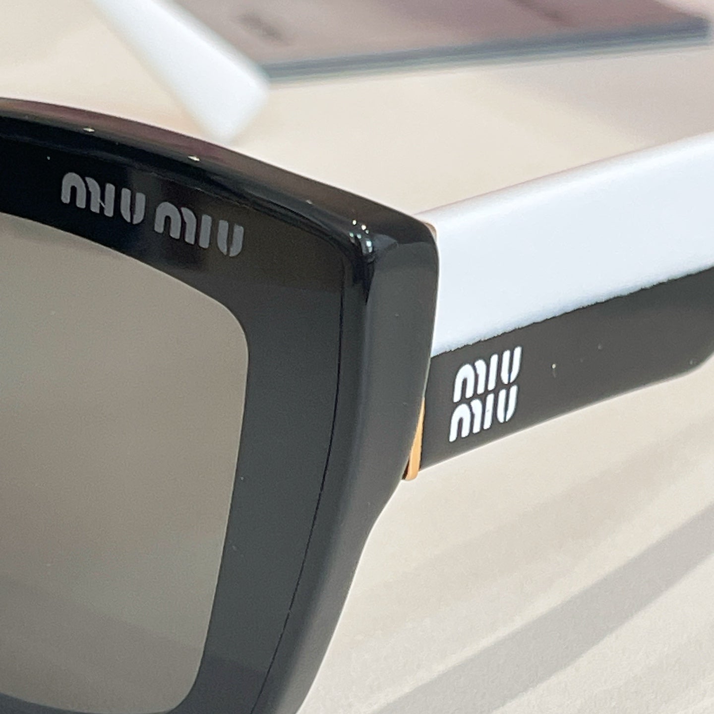 MiuMiu sunglasses temple with brand logo on black frame