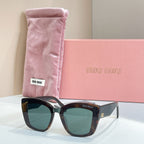 MiuMiu square sunglasses with dark frames and green-tinted lenses, in pink pouch