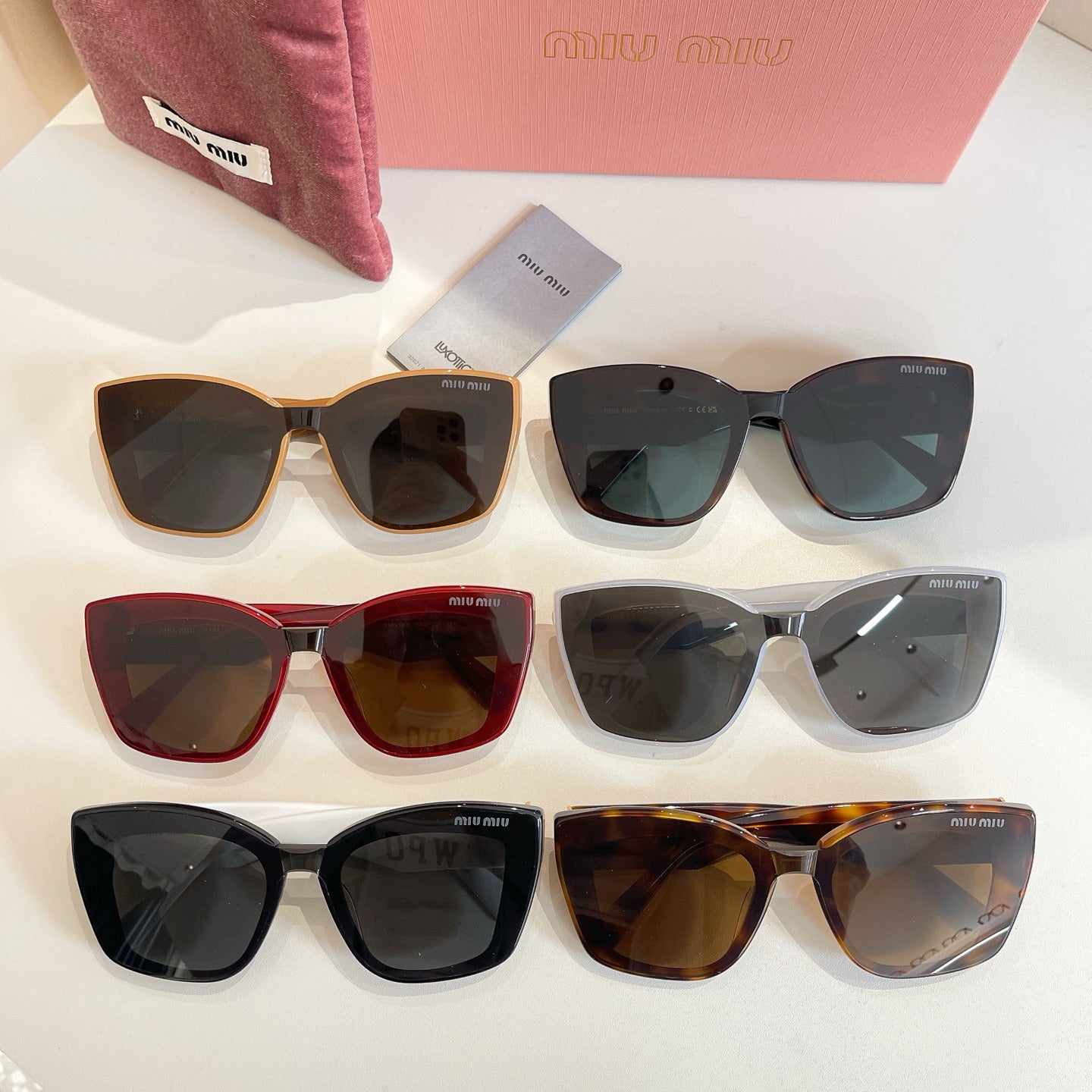 Assorted MiuMiu square sunglasses with mixed frames and dark lenses on display