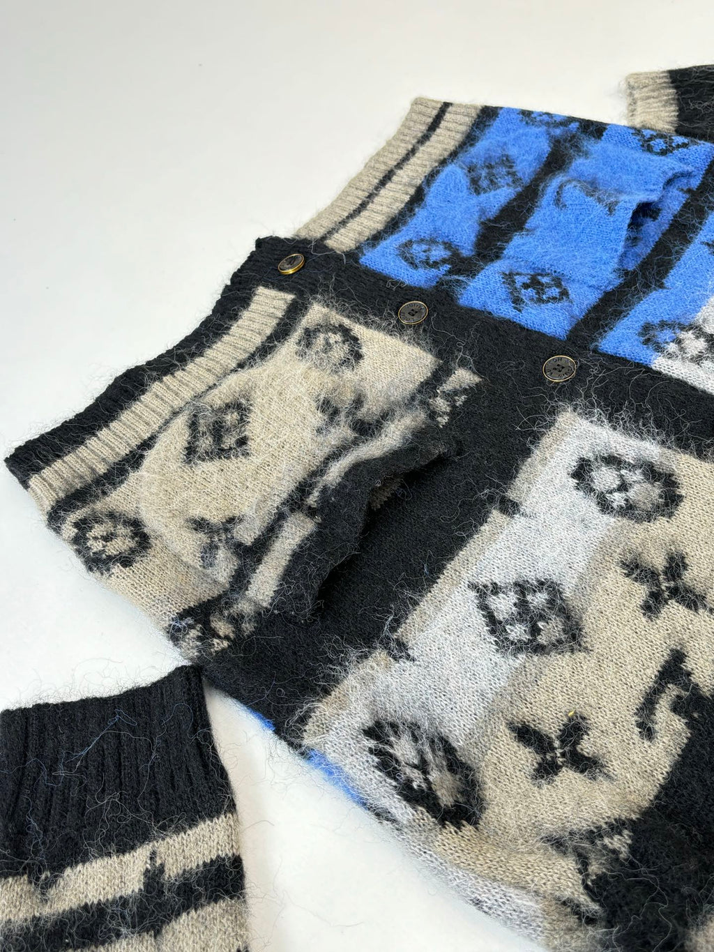 Knit cardigan sleeve with blue patterned panel and black striped cuffs