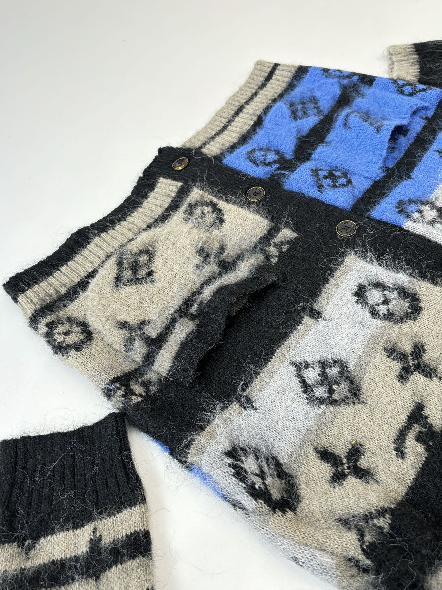 Knit cardigan sleeve with blue patterned panel and black striped cuffs