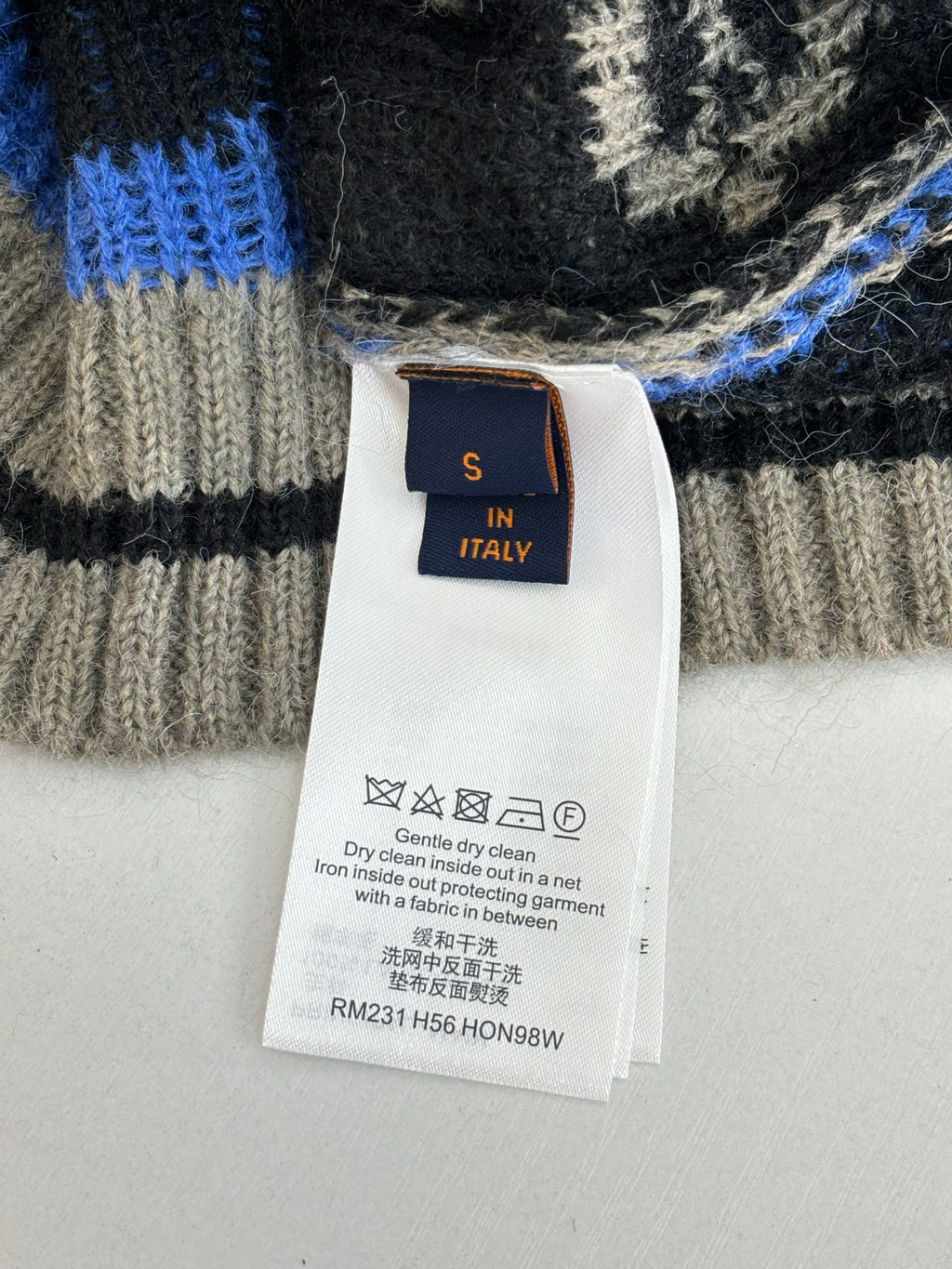 In Italy care label on knit cardigan in blue, black, and cream
