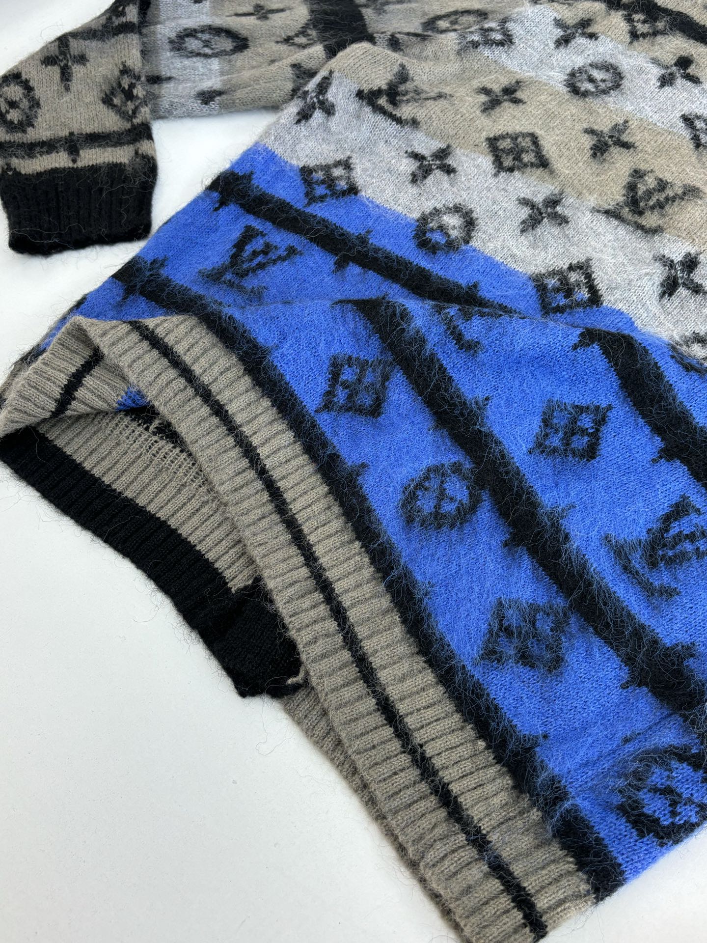 Knit cardigan shoulder and sleeve, blue band with monogram and striped rib hem