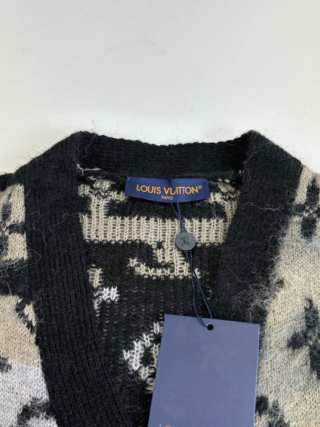 Louis Vuitton knit cardigan neckline with black collar and beige monogram knit tag