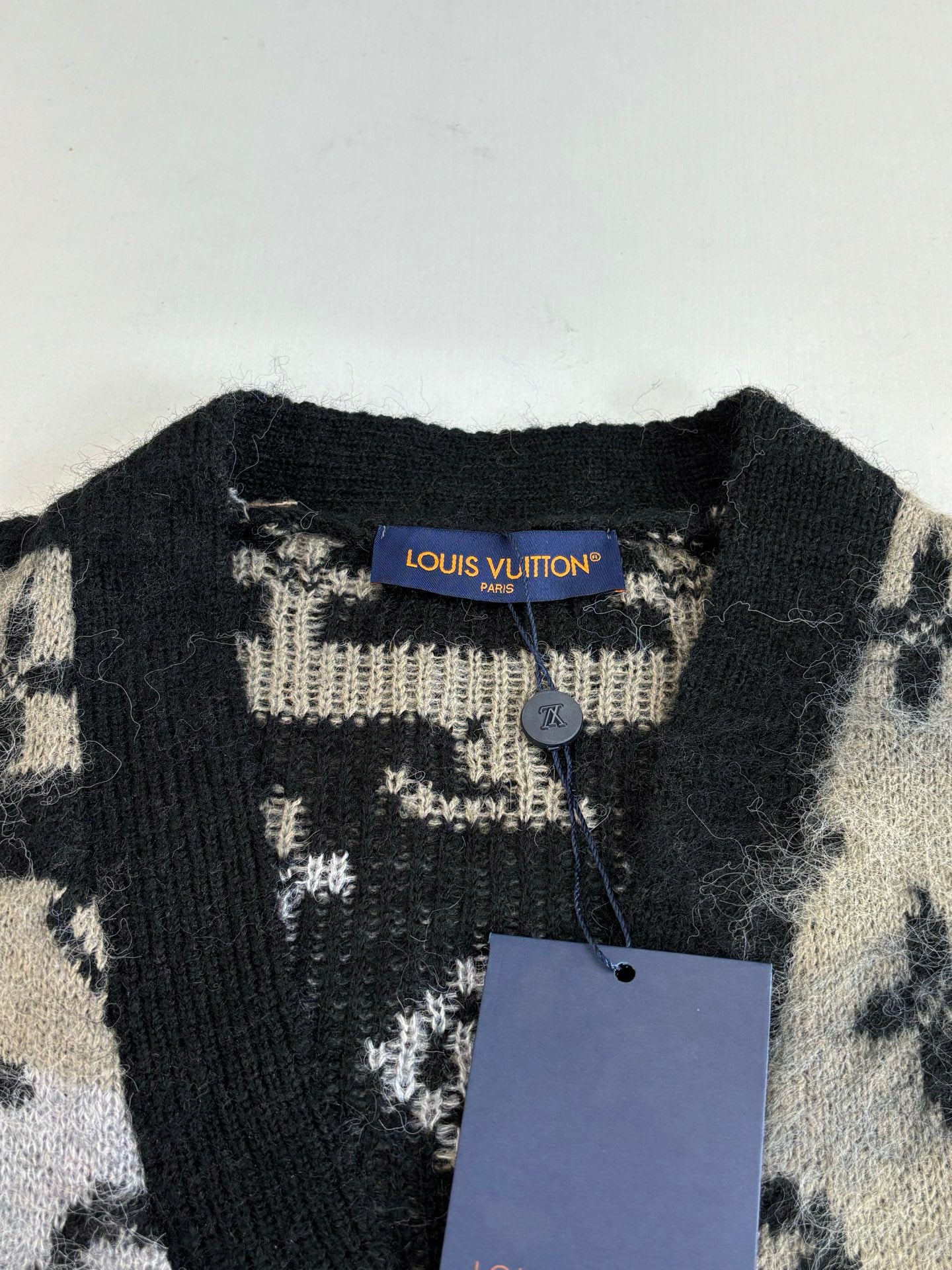 Louis Vuitton knit cardigan neckline with black collar and beige monogram knit tag