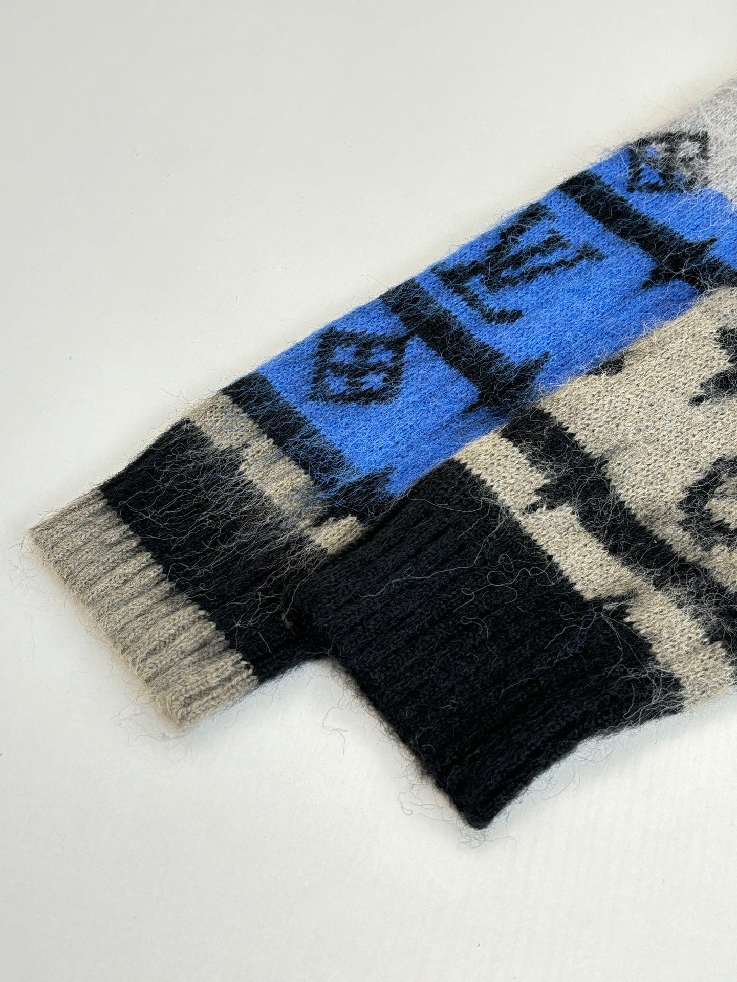Knit cardigan hem detail, black and cream with blue monogram stripe