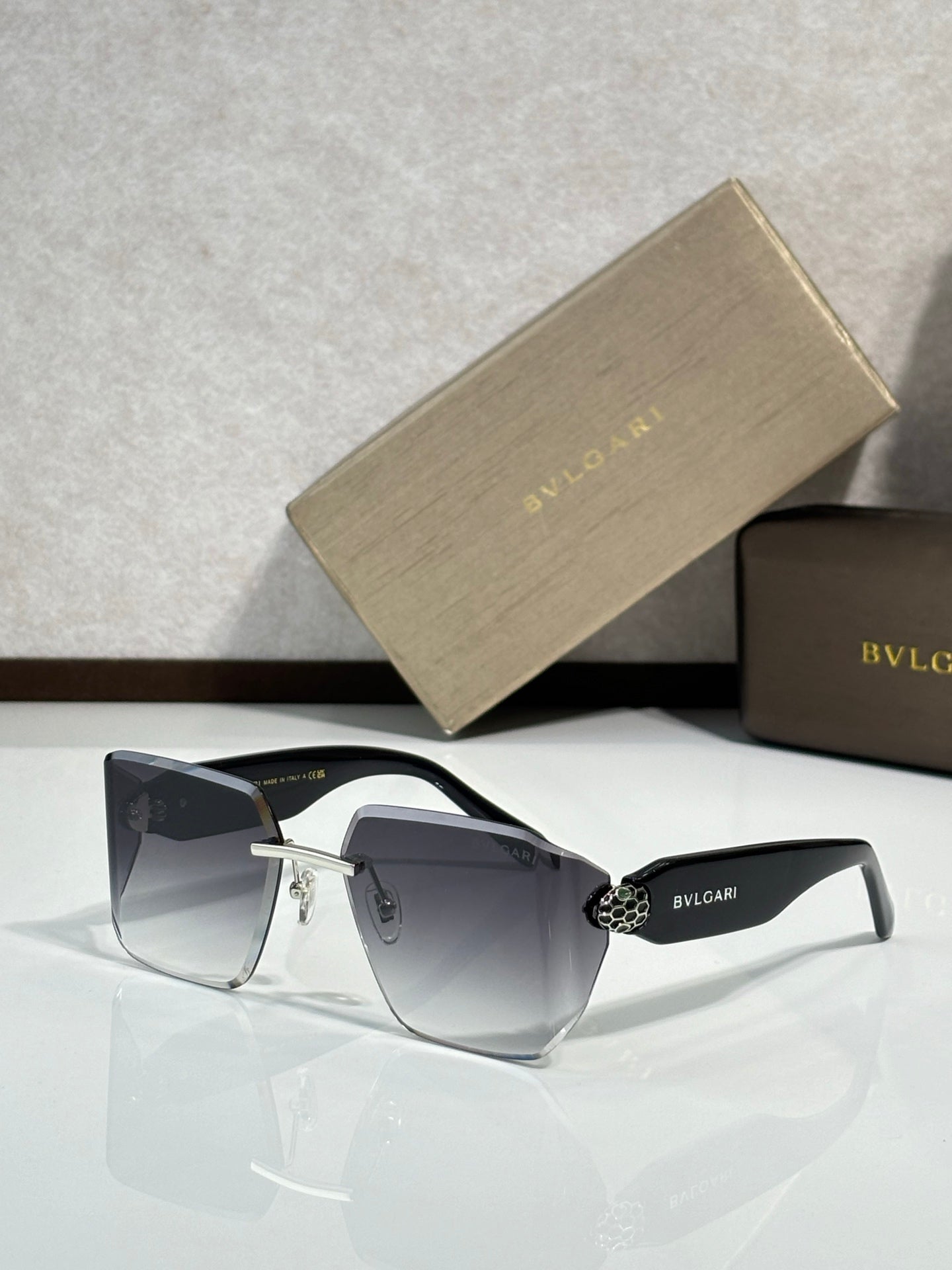 Bvlgari sunglasses with dark blue gradient lenses and silver frame, gold-toned hinge