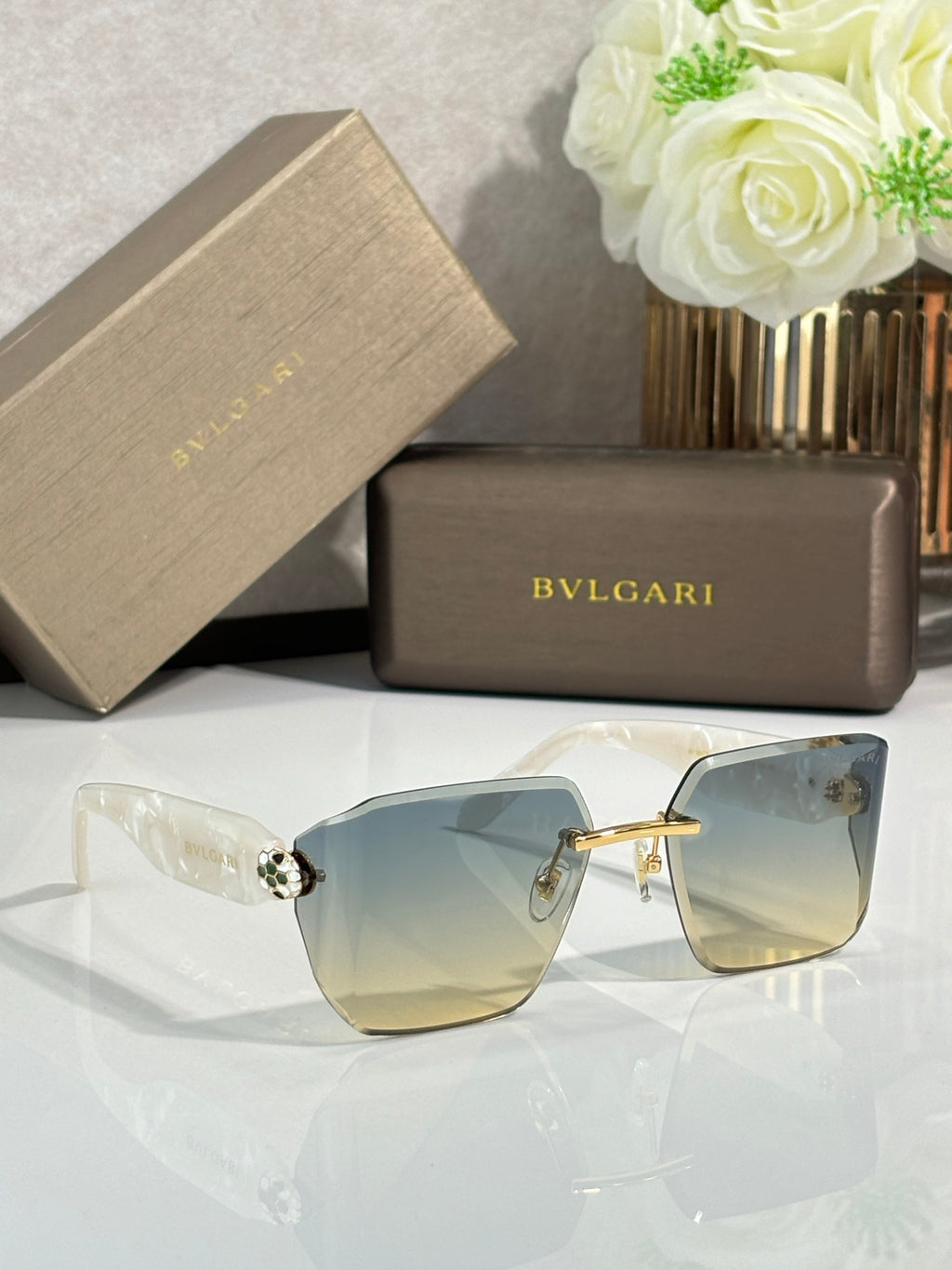 Bvlgari sunglasses with pale gradient lenses and light frame, crystal-like hinge ornaments