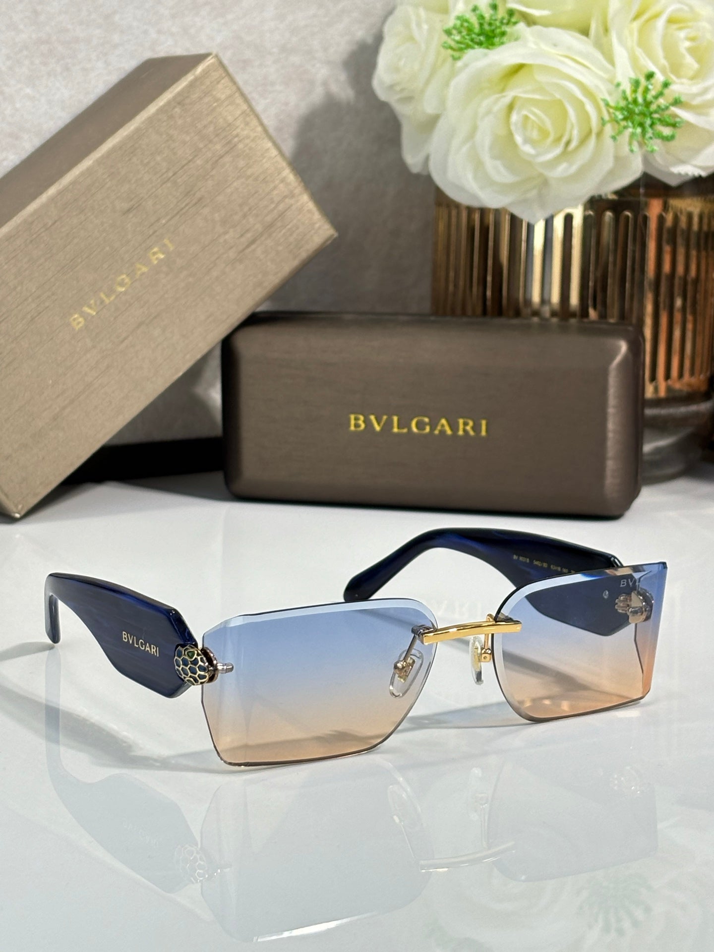 Bvlgari square sunglasses with blue lenses, navy temples, and gold-tone frame