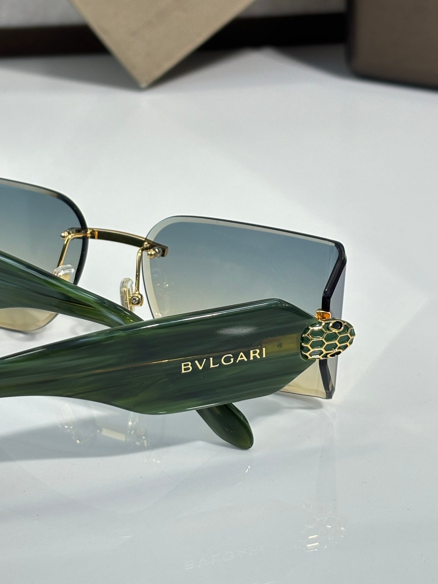 Bvlgari sunglasses close-up with green temple and gold-tone frame