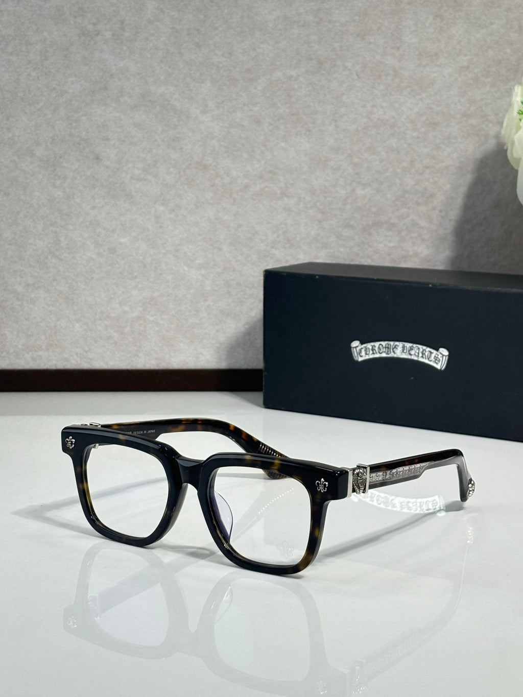 Clear-lens glasses with dark frame and chrome temple details