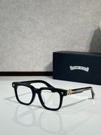 Clear-lens glasses with black frame, gold logo, and chrome hinges