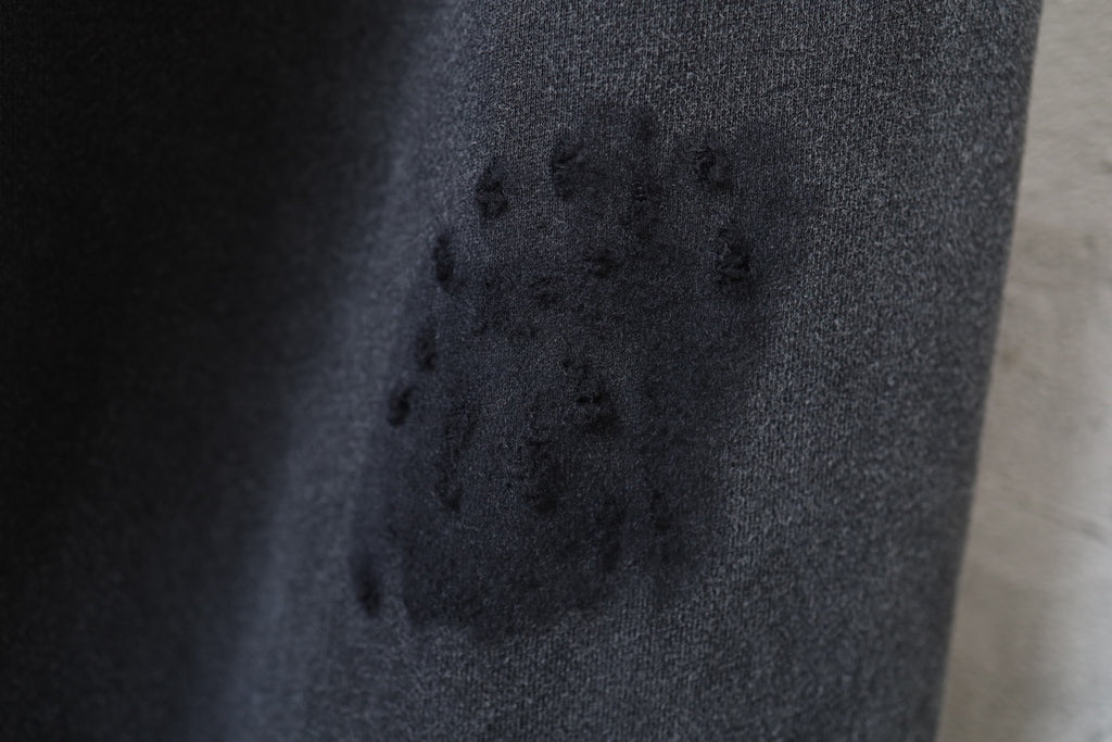 Black fabric close-up with scattered marks and textured woven surface