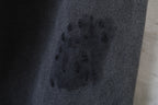 Black fabric close-up with scattered marks and textured woven surface
