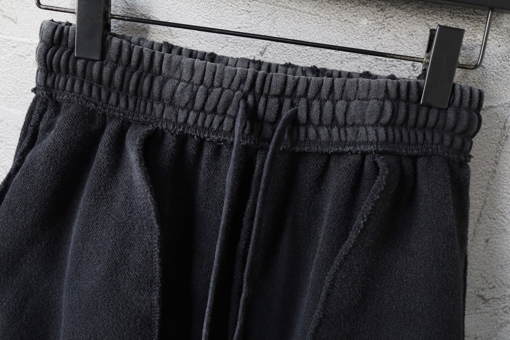 Black elastic waistband with gathered fabric above wide straight leg openings
