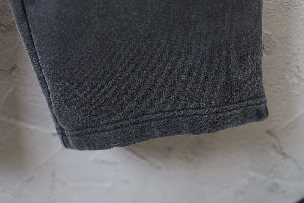 Black pants hem with stitched cuff and smooth woven texture