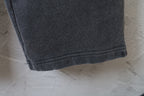 Black pants hem with stitched cuff and smooth woven texture
