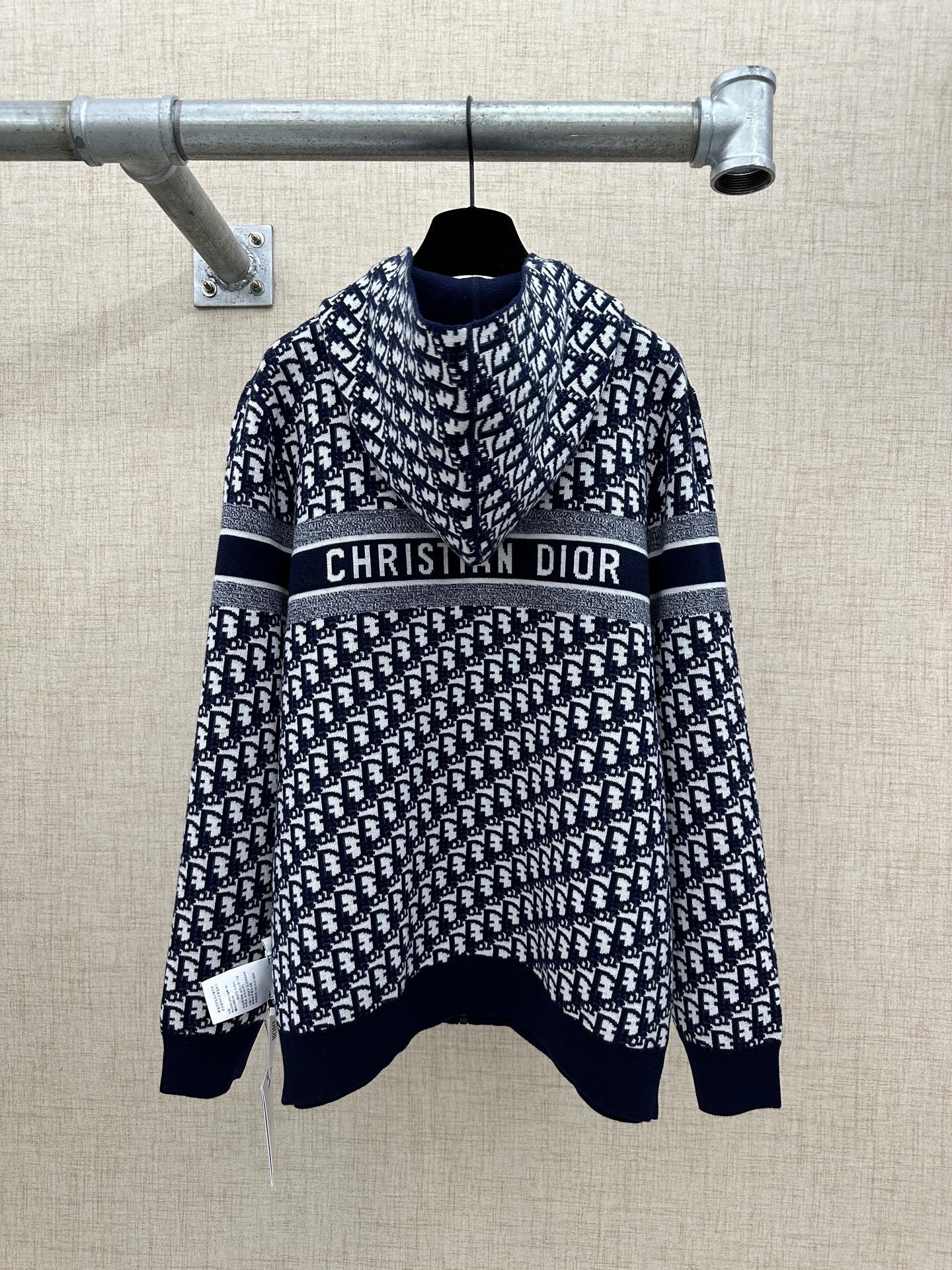 Navy and white patterned zip-up hoodie with “Christian Dior” logo stripe across chest.