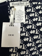 Brand tags and label on navy and white patterned zip-up hoodie fabric.