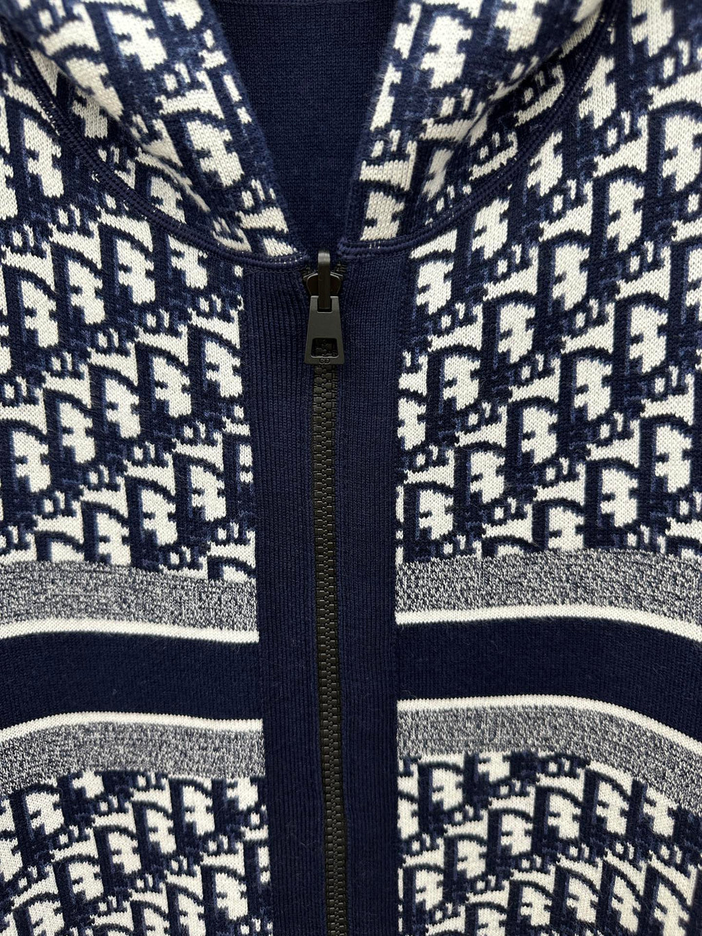 Patterned zip-up hoodie close-up with gold zipper and silver-striped trim