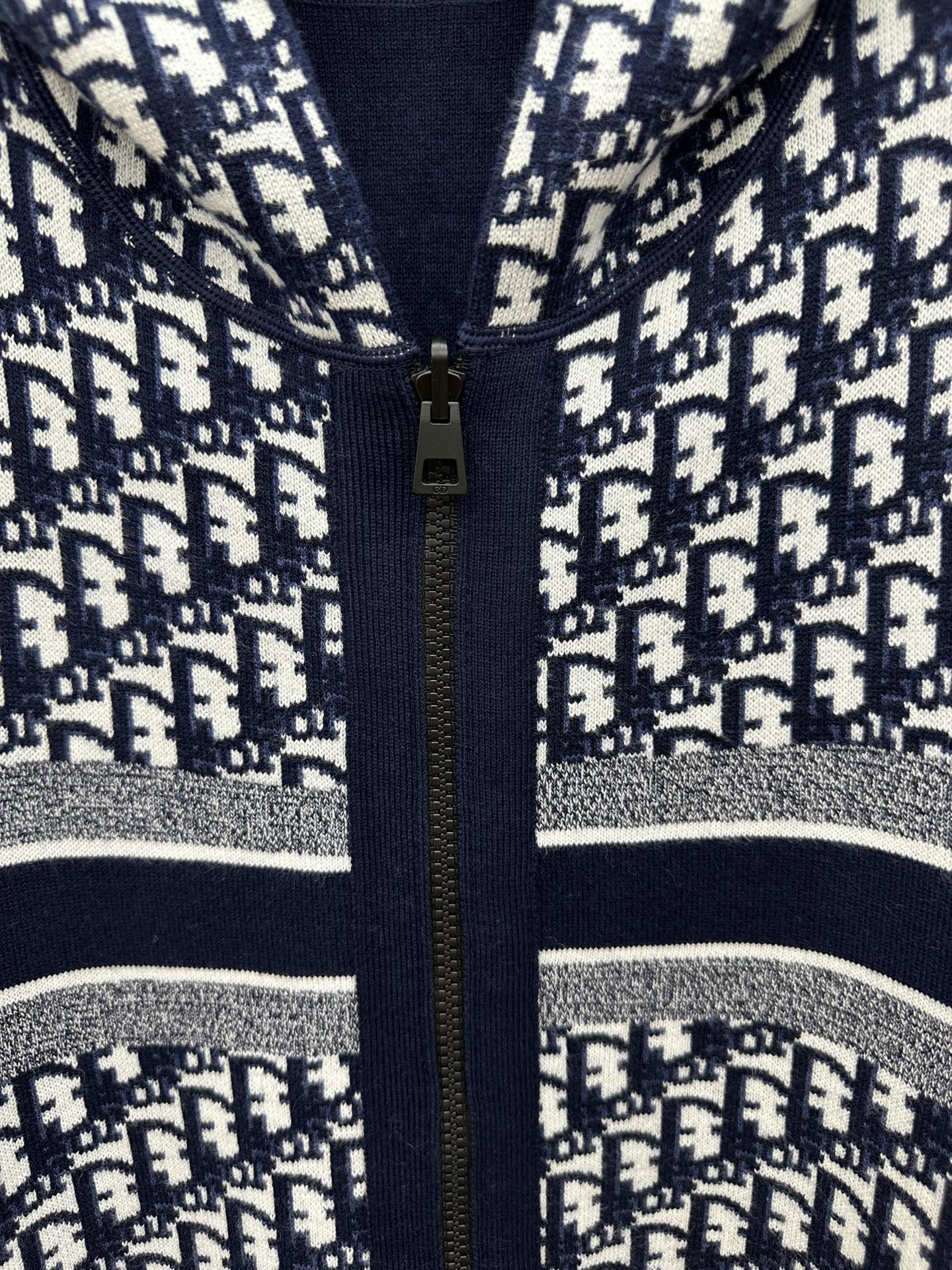 Patterned zip-up hoodie close-up with gold zipper and silver-striped trim