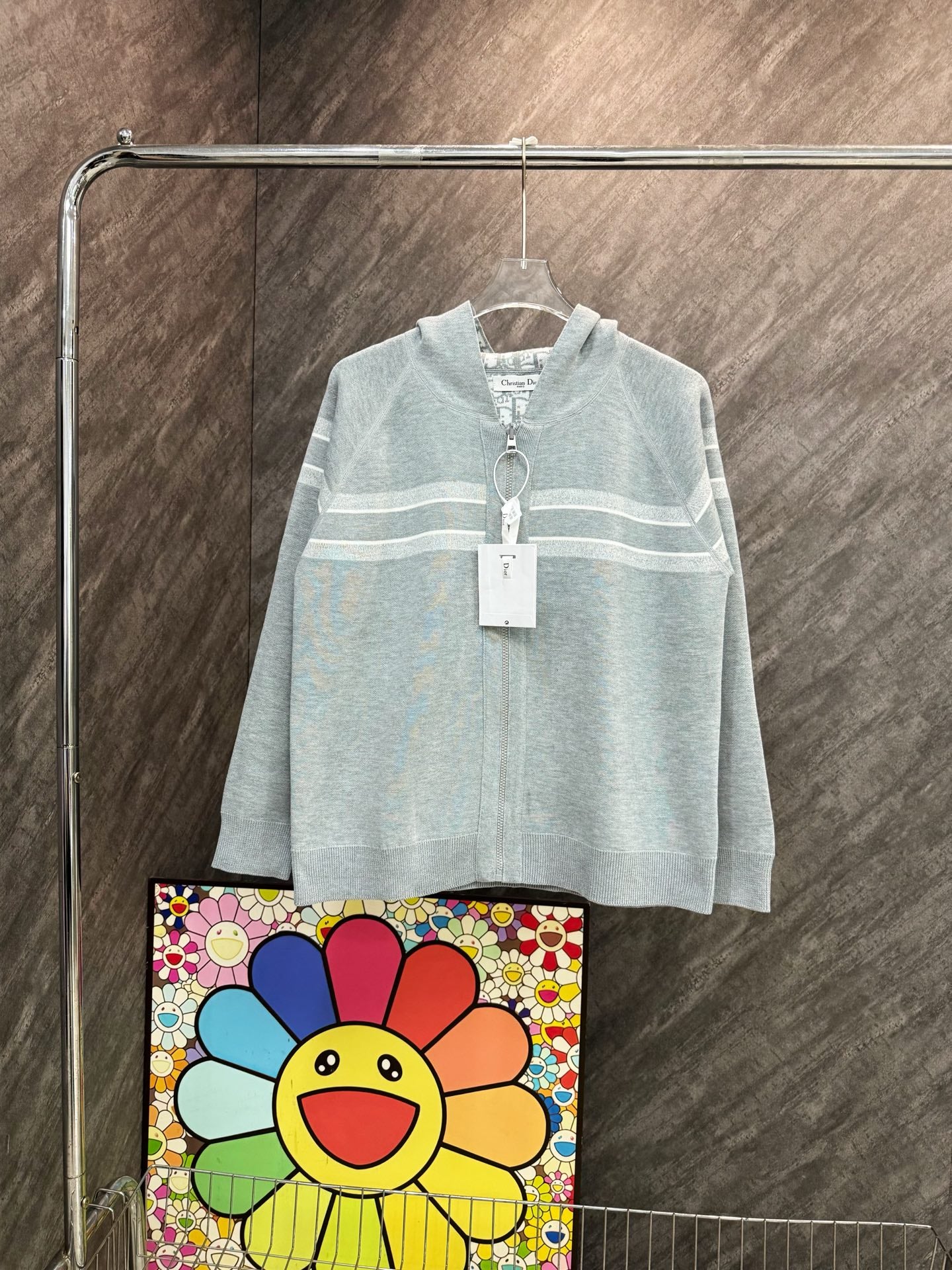 Light blue hooded zip sweatshirt with striped chest design and drawstring hood.
