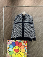 Black and white hooded zip sweatshirt with allover pattern and striped hem trim.